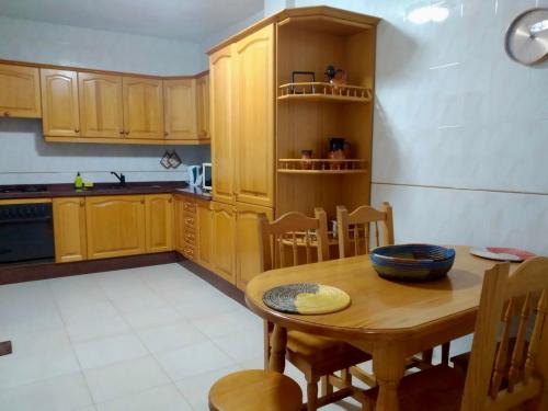 a kitchen with wooden cabinets and a wooden table at CASA LOS VIEJOS in Frontera