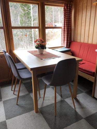 a table and chairs in a room with a window at Fjordgløtt Camping/Hytter in Rødberg