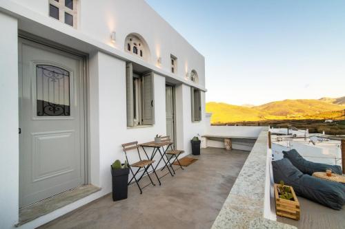 a balcony with a door and a table and chairs at Livadi house Tinos in Káto Klísma