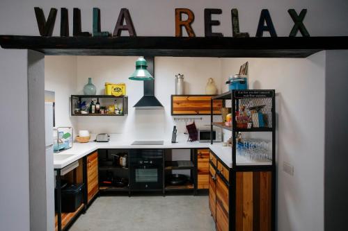a kitchen with white countertops and a black refrigerator at VILLA RELAX, LA GRACIOSA in Caleta de Sebo