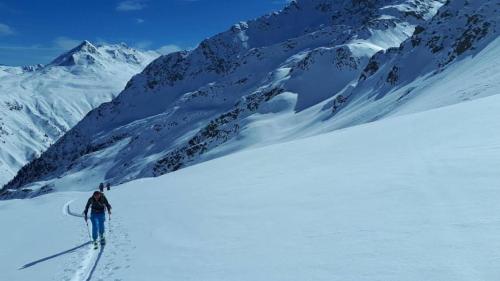 Un uomo sta sciando giù da una montagna innevata di Haus Troger a Sankt Jakob in Defereggen