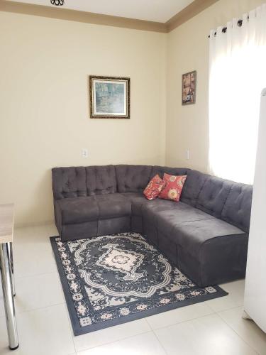 a leather couch in a living room with a rug at Felipe Family Houses - Casas de temporada in Foz do Iguaçu
