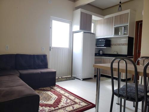 a living room with a couch and a table and a refrigerator at Felipe Family Houses - Casas de temporada in Foz do Iguaçu