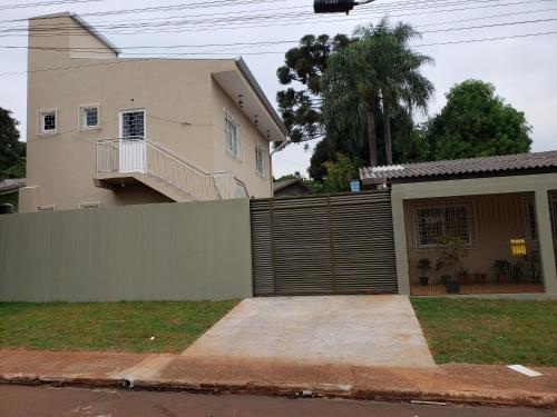 a house with a fence and a garage at Felipe Family Houses - Casas de temporada in Foz do Iguaçu