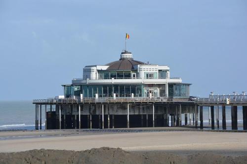 a building on the beach next to the ocean at ROYAL GARDENS DAKTERRAS in Blankenberge