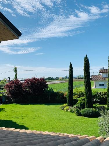 a garden with trees and grass and a house at B&B Beauty House in Cesena