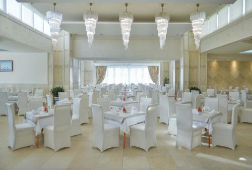 a banquet hall with white tables and white chairs at Mediteran Hotel & Resort in Budva
