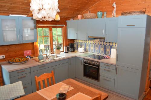 eine Küche mit blauen Schränken und einem Tisch im Zimmer in der Unterkunft Ferienhaus Thelen in Niederhersdorf