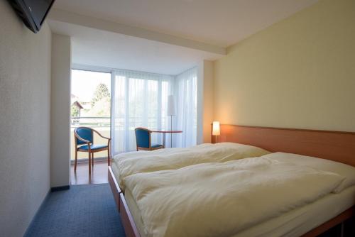 Un pat sau paturi într-o cameră la Hotel Klausenhof Flüeli