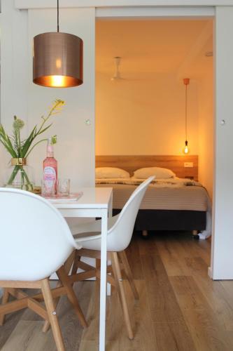 a bedroom with a bed and a table and chairs at Appartement HideAway Nr 17 - Amelander Kaap in Hollum