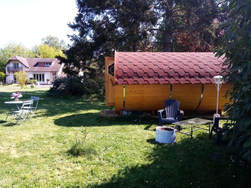 a small cabin with a red roof in a yard at Havre de paix au bords de l'Eure - divers hébergements in Neuilly