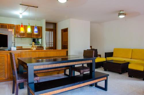 a living room with a table and a couch at Hotel Santorini Express y Cabañas in Santa Marta