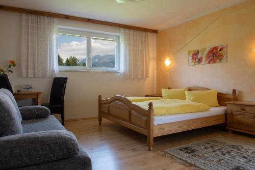 a bedroom with a bed and a window and a couch at Familiengasthof St. Wolfgang in Spittal an der Drau