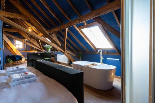 Habitación con baño con bañera y lavabo. en Boutique hotel Lytel Blue en Riethoven