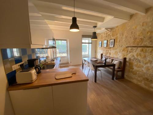 - une cuisine et une salle à manger avec un comptoir et une table dans l'établissement Appartement Saint Emilion, à Saint-Émilion