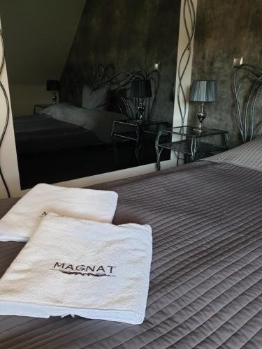 a bed with two towels on top of it at Hotel Magnat in Suchedniów