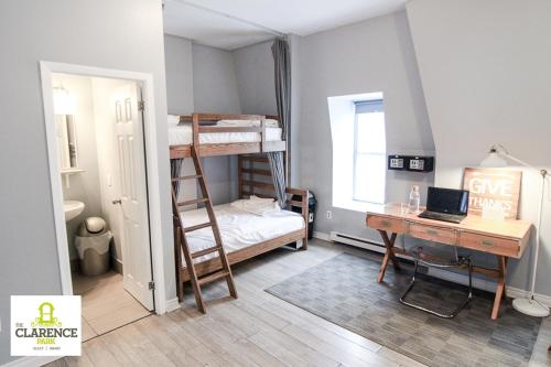 a bedroom with bunk beds and a desk with a laptop at The Clarence Park in Toronto