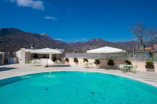 a swimming pool with tables and chairs and umbrellas at Hotel le Rocce - Agerola, Amalfi Coast in Agerola