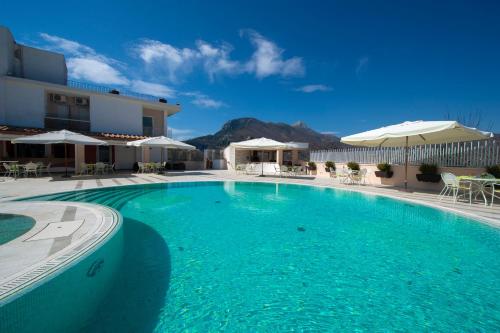 a large swimming pool in a hotel with mountains in the background at Hotel le Rocce - Agerola, Amalfi Coast in Agerola