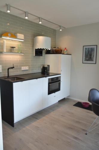 a kitchen with white cabinets and a black sink at Apartment Moore in Reit im Winkl