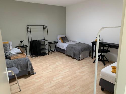 a room with two beds and a desk and a mirror at Apartments Zaanse Schans and Amsterdam in Wormer