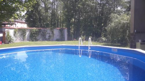 une piscine dans une cour à côté d'une maison dans l'établissement Le relais champêtre, à Joux