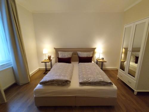 a bed in a room with two tables and two lamps at Villa am Park in Meiningen