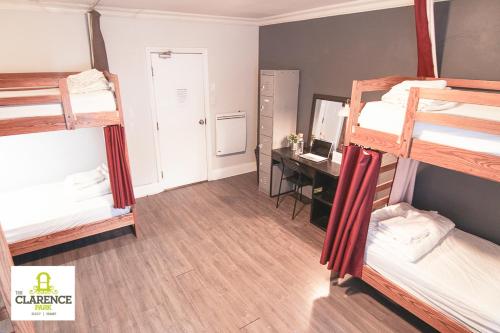 a room with three bunk beds and a desk at The Clarence Park in Toronto