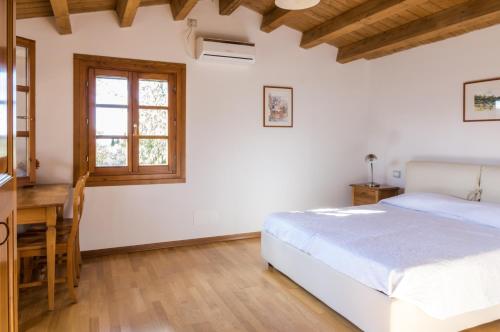 a bedroom with a bed and a desk and a window at CASE&COLLINE Seaview in Guardistallo