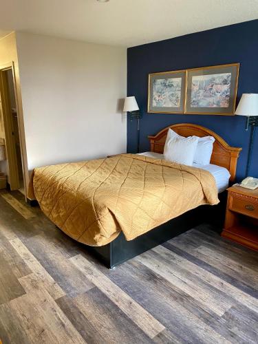 a bedroom with a large bed with blue walls at Motel 6 Marianna, FL in Marianna