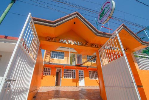an orange building with a gate in front of it at El paraíso de Zacatlán DEPARTAMENTO con JARDÍN, 11 pax in Zacatlán