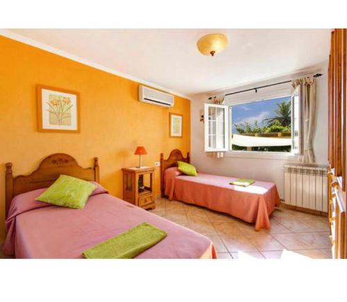 a bedroom with two beds and a window at Villa Ingrid in Alaior