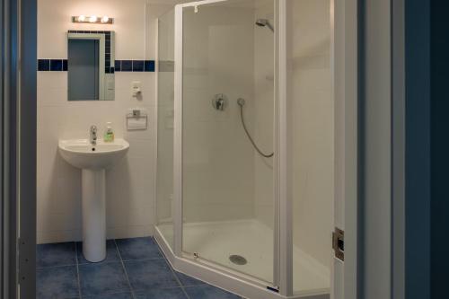 a bathroom with a shower and a sink at Treetop Lodge - Acheron Holiday Home in Hanmer Springs