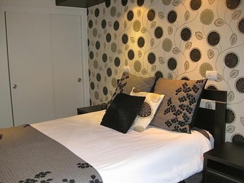 a bedroom with a bed with white sheets and pillows at Les Fleurs avec Spa - Ohakune Holiday Home in Ohakune