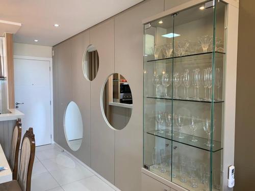 a glass display case filled with wine glasses at Apartamento Moderno na Praia dos Ingleses in Florianópolis