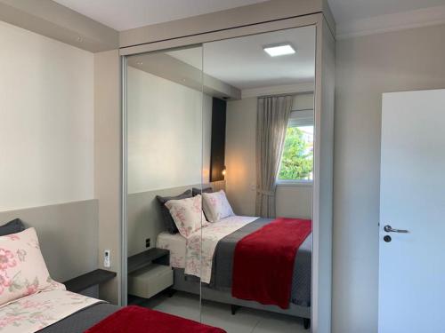 a bedroom with a mirror next to a bed at Apartamento Moderno na Praia dos Ingleses in Florianópolis