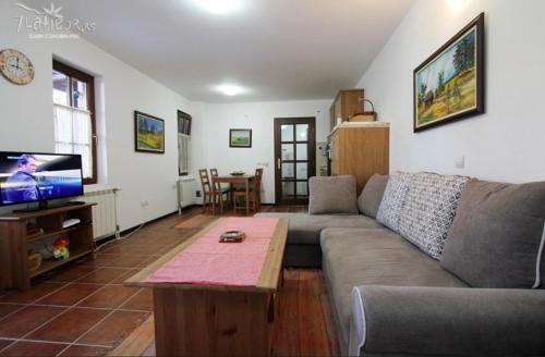 - un salon avec un canapé, une table et une télévision dans l'établissement Apartman KAMENKO, à Zlatibor