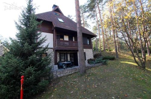 une maison dans les bois avec un arbre dans l'établissement Apartman KAMENKO, à Zlatibor