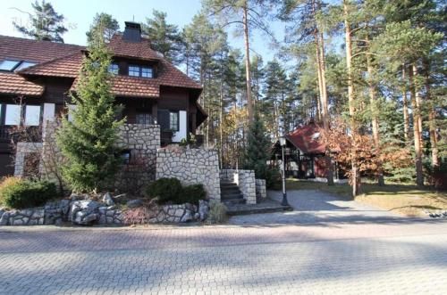 une maison avec un mur en pierre en face d'une allée. dans l'établissement Apartman KAMENKO, à Zlatibor