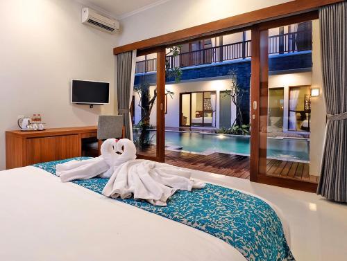 a bedroom with a bed with a towel animal on it at Mahana Living in Denpasar