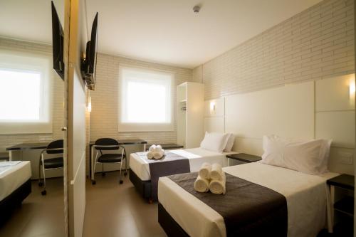 Säng eller sängar i ett rum på Hotel Confiance Barigui