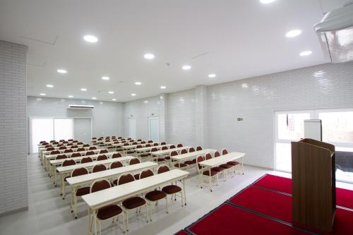 クリチバにあるHotel Confiance Bariguiのテーブルと椅子が並んだ広い部屋