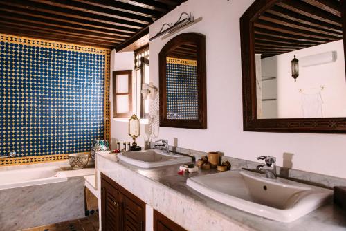 une salle de bain avec deux lavabos et un miroir dans l'établissement Riad Maison Bleue and Spa, à Fès