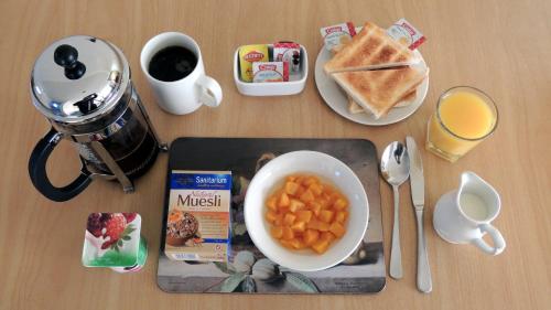een tafel met een bord eten, geroosterd brood en een kom wortels bij Central Motor Lodge in Morrinsville