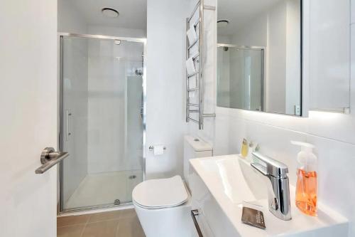 a bathroom with a toilet and a sink and a shower at Amazing Harbour, Skytower and Rangitoto Views in Auckland