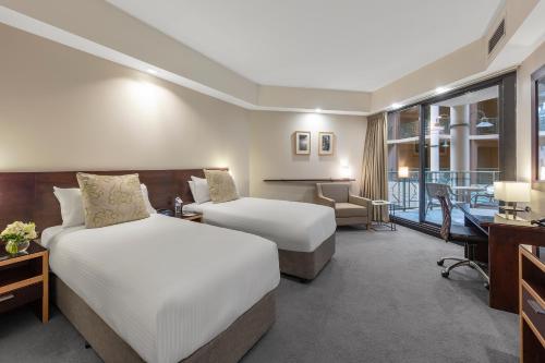 a hotel room with two beds and two lamps at Amora Hotel Riverwalk in Melbourne