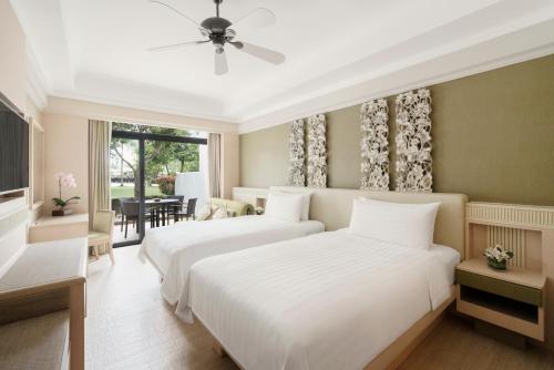 a bedroom with two beds and a dining room at Shangri-La Rasa Sentosa, Singapore in Singapore