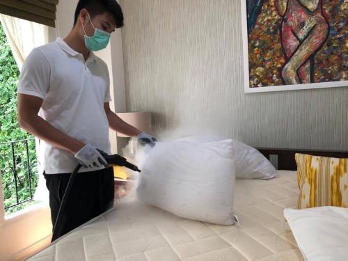 a man in a mask and gloves cutting a pillow at Casa Blanca Boutique Hotel - SHA Plus in Phuket Town