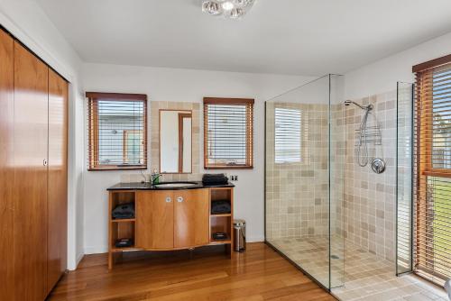 a bathroom with a shower and a sink at Wheelhouse Apartments in Strahan