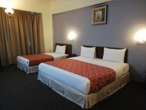 una camera d'albergo con due letti e una finestra di Hotel Damai a Parit Buntar